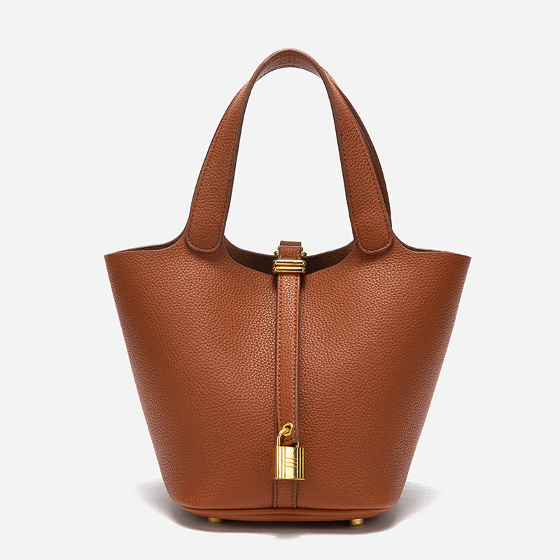 Sac à main avec surface grainée, anses courtes et détail métallique décoratif